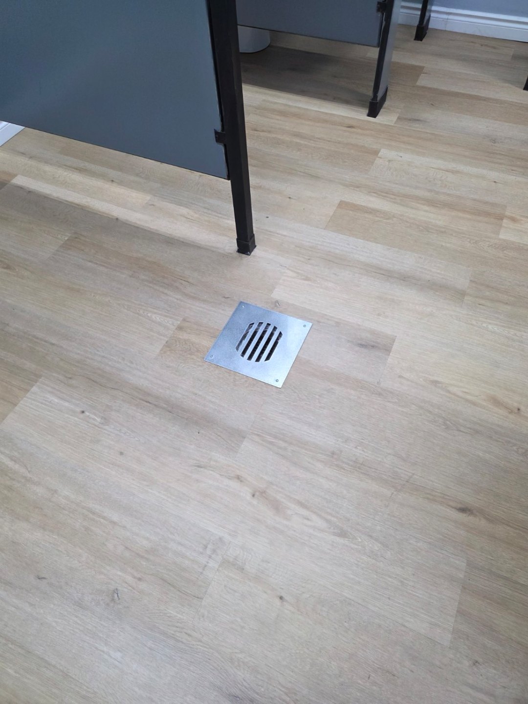 Completed commercial flooring around a square floor drain