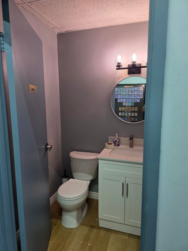 Completed compact employee washroom with vanity and toilet