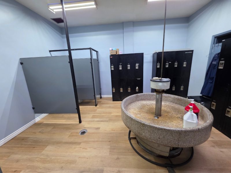 Completed locker room with black lockers, restored partitions and wood-look flooring